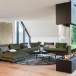 Bielefelder Werkstätten Sofa Long Island, Sofa mit grünem Bezug vor Kamin