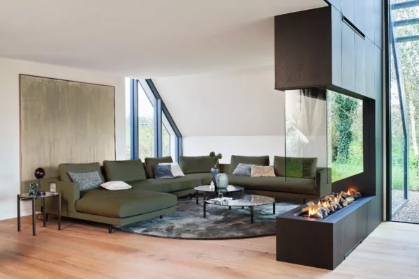 Bielefelder Werkstätten Sofa Long Island, Sofa mit grünem Bezug vor Kamin