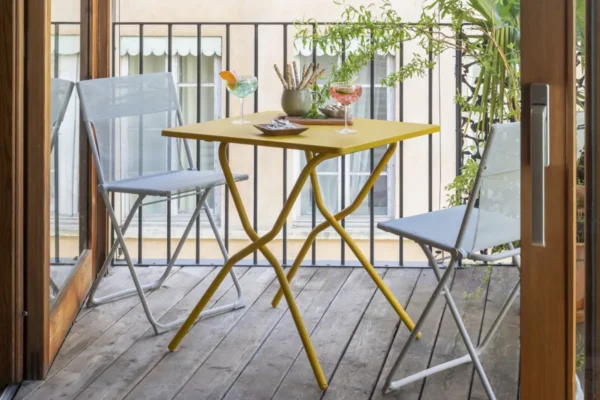 Lafuma Gruppe Balcony, gelber Tisch und weiße Stühle Lafuma Gruppe Balcony, gelber Tisch und weiße Stühle