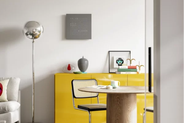 QLOCKTWO Earth 45 Grey Pepper QLOCKTWO Earth 45 Grey Pepper, Wanduhr über gelbem Sideboard