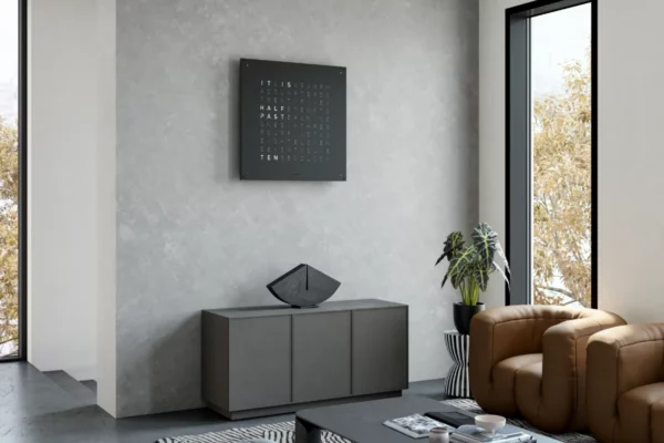 QLOCKTWO Earth 90 Black Pepper QLOCKTWO Earth 90 Black Pepper, Wanduhr an grauer Wand pber Kommode