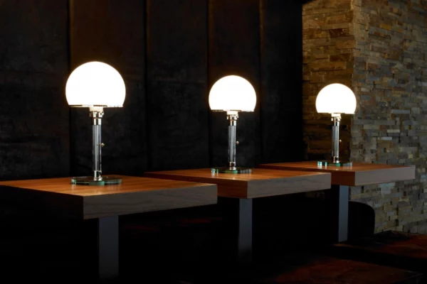 Tecnolumen Wagenfeldleuchte WG 24 Tecnolumen Wagenfeldleuchte WG 24, drei Leuchten auf Tischen